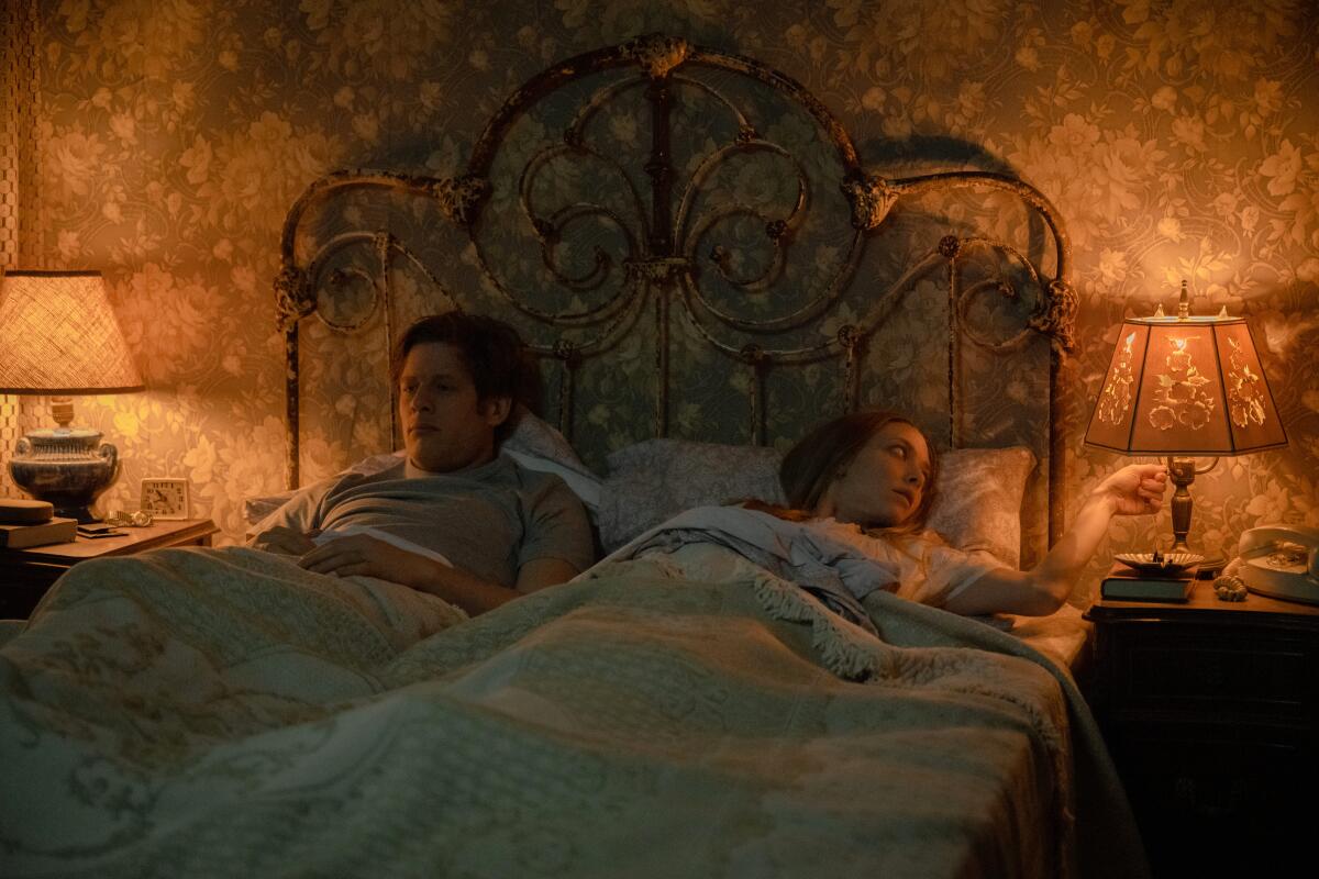 A man and woman lie in bed.