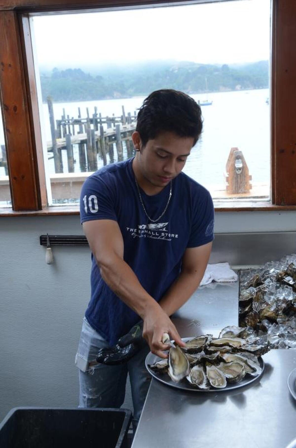Jonathan Cortez shucks fresh oysters.