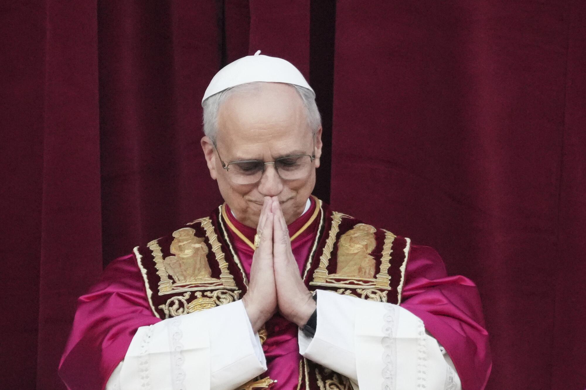 Pope Leo XIV bends his head in prayer at St. Peter's Basilica.