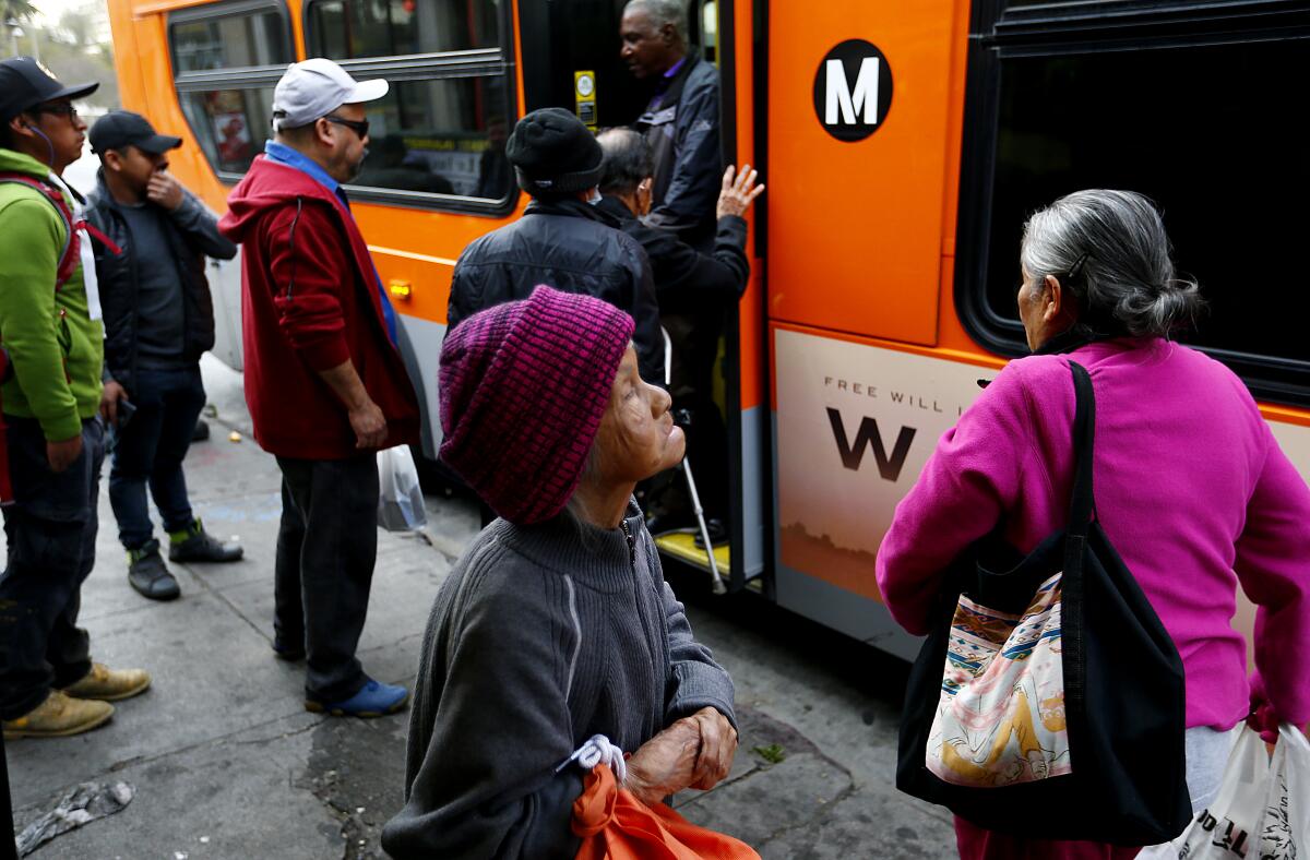 Commuters catch a bus at 7th and Alvarado streets in Westlake