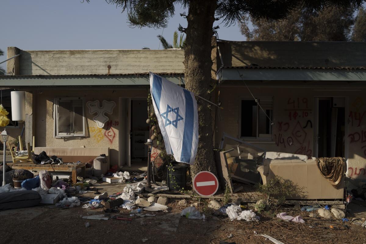 An Israeli flag hangs between destroyed houses.