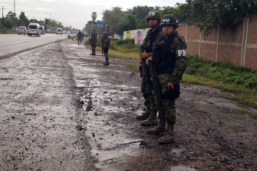 Federal troops take over the port of Lazaro Cardenas and the municipal police headquarters in Mexico's troubled Michoacan state in November. Authorities said Monday that the city mayor has been arrested and accused of kidnapping, extortion and links to organized crime.