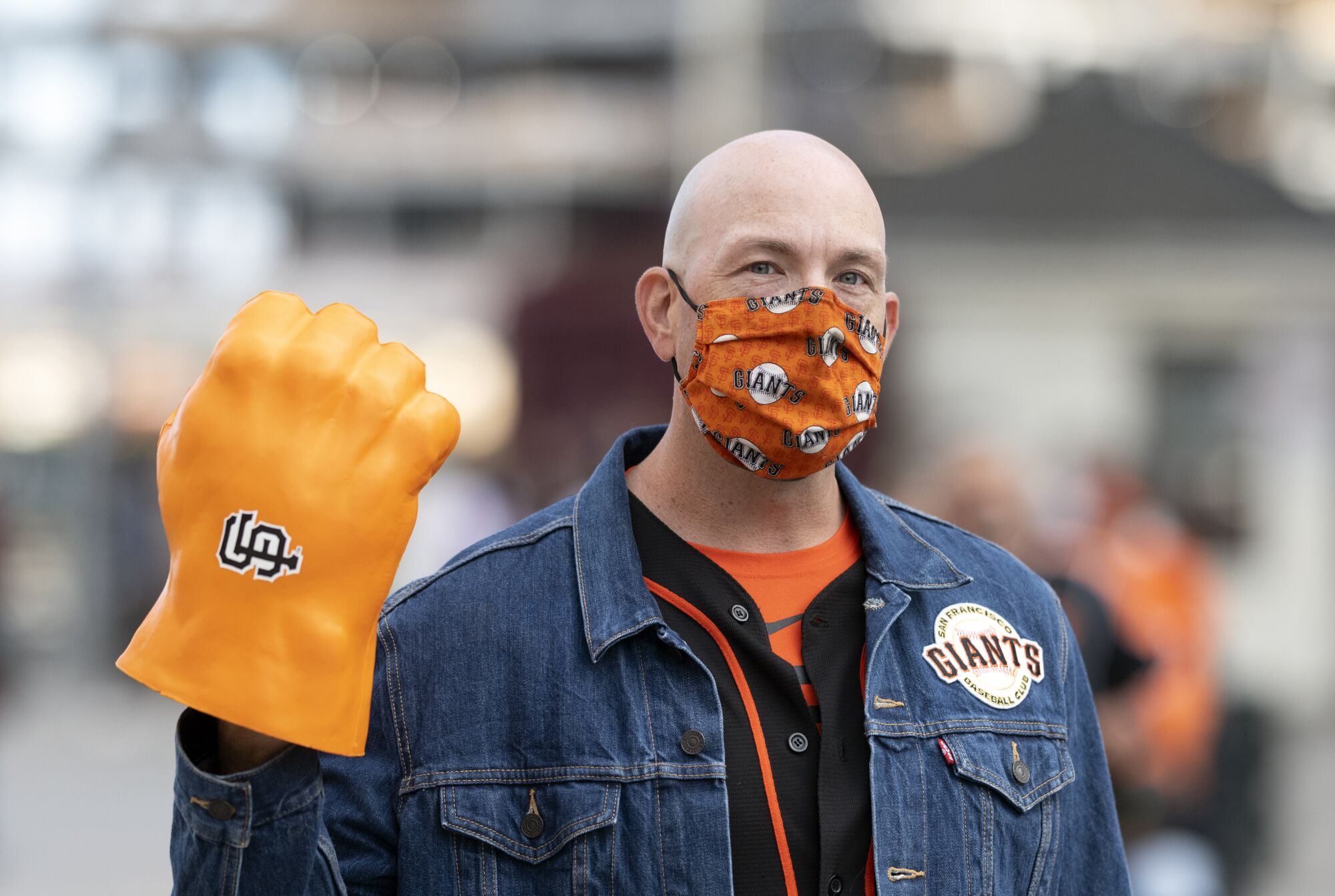 Giants fan Dave Lowe holds up a large replica of a fist on his hand with the Giants logo on it