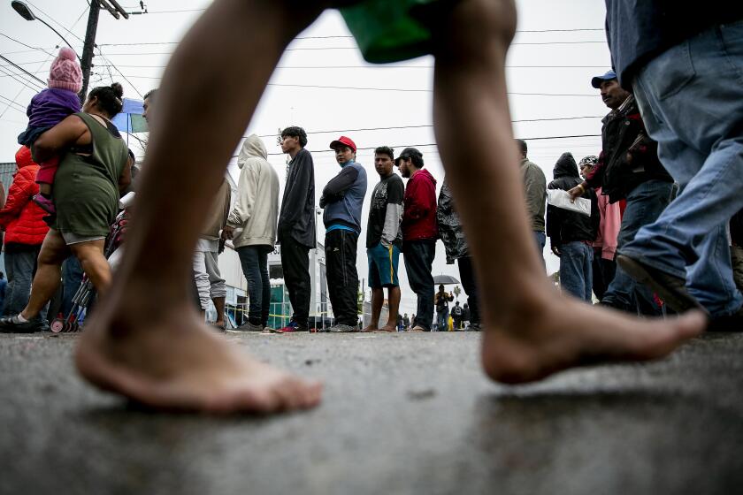 Central American migrants line up for food outside of the Benito Juarez sports complex  in Tijuana, Mexico. 