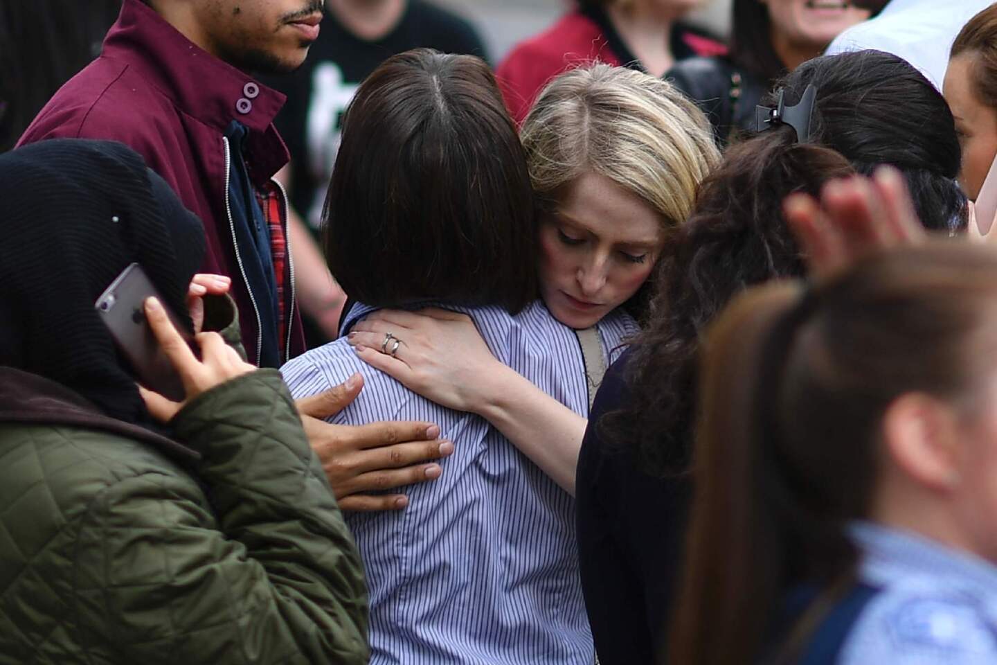 Workers hug each other after being evacuated from the Arndale Centre shopping mall in Manchester on Tuesday following a security alert.