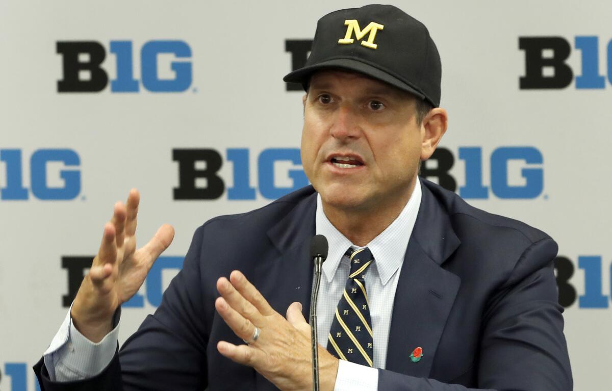 Michigan coach Jim Harbaugh responds to a question during Big Ten Conference media days in July.