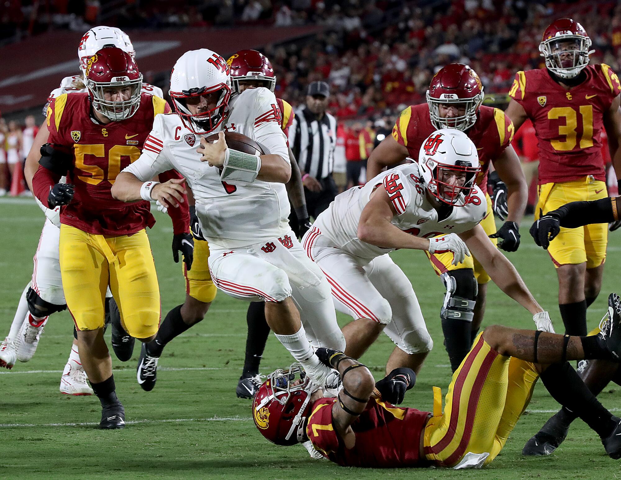 Utah quarterback Cameron Rising runs over USC strong safety Chase Williams on his way to scoring a touchdown.