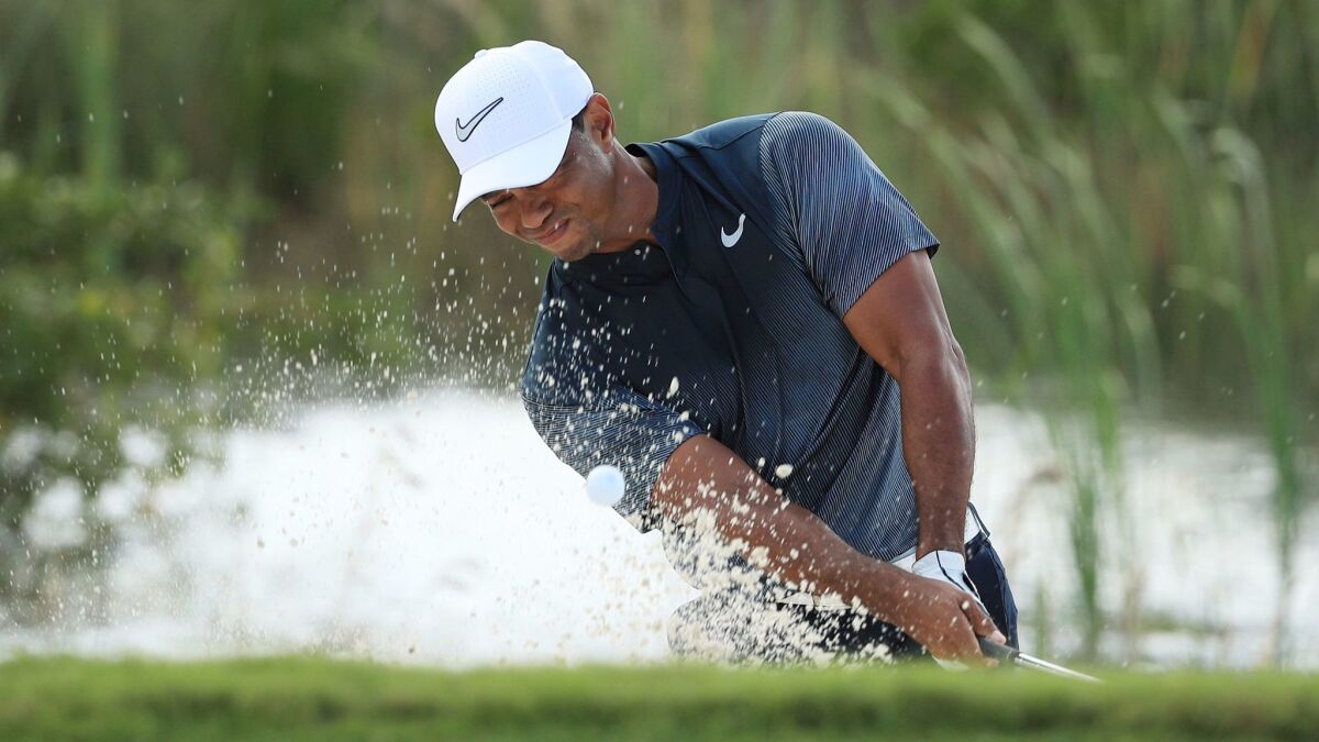 Tiger Woods plays a shot from a bunker on the fifth hole during the third round of the Hero World Challenge at Albany.