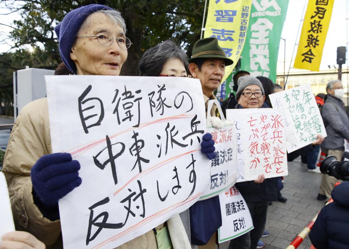 People opposed to Japan's planned troop dispatch display placards outside the official residence of Prime Minister Shinzo Abe in Tokyo on Friday.