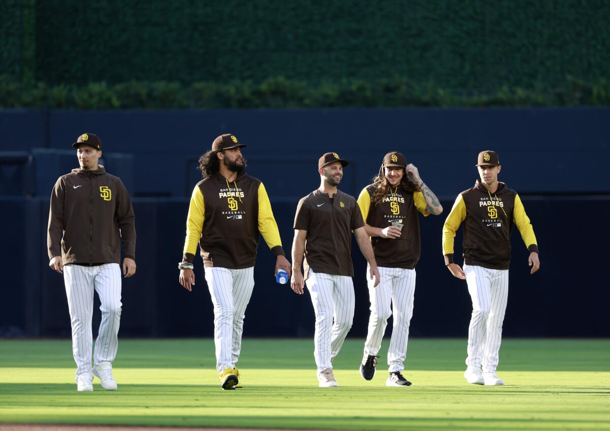 Padres pitchers (from left) Blake Snell, Sean Manaea, Nick Martinez, Mike Clevinger and MacKenzie Gore walk on the field.
