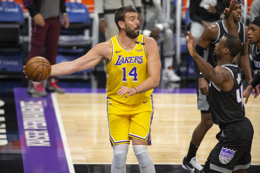 Lakers center Marc Gasol looks to make a pass as he is defended by Kings forward Harrison Barnes.