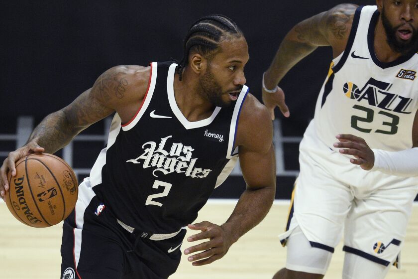Los Angeles Clippers forward Kawhi Leonard, left, is defended by Utah Jazz forward Royce O'Neale.