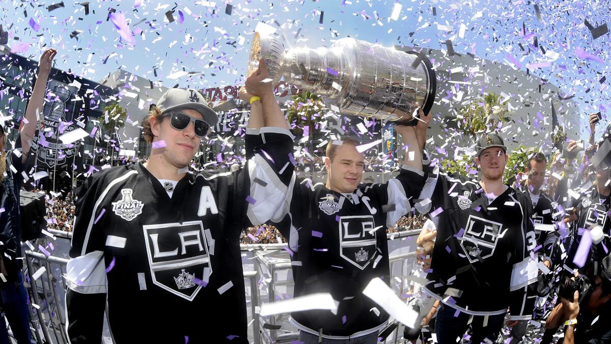 Kings teammates (from left to right) Anze Kopitar, Dustin Brown and Jonathan Quick celebrate the team's Stanley Cup victory in front of Staples Center on June 16.