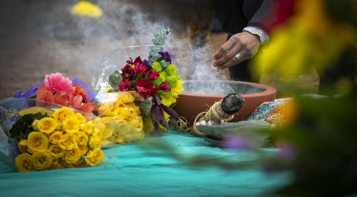 A mourner sprinkles incense on Wednesday as he joins others paying respect to people who died in Los Angeles County and whose bodies were not claimed.