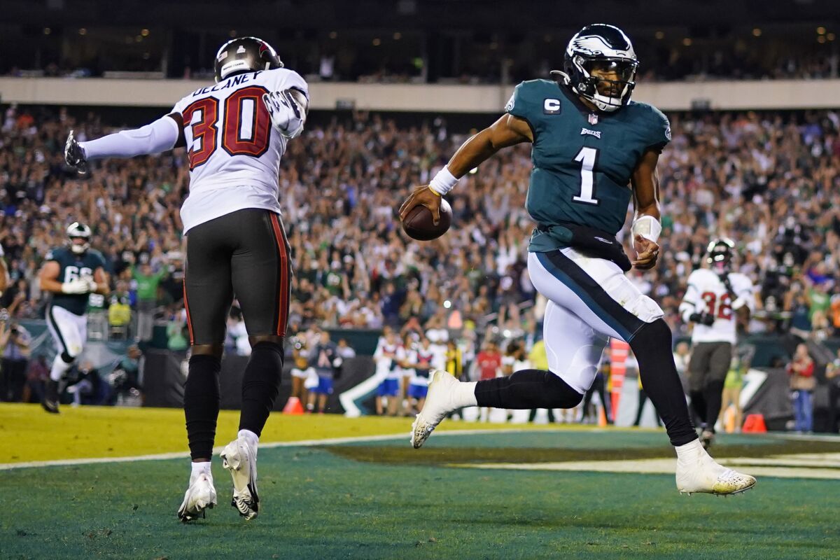 Philadelphia Eagles quarterback Jalen Hurts (1) scores a touchdown in front of Tampa Bay Buccaneers defensive back Dee Delaney (30) during the second half of an NFL football game Thursday, Oct. 14, 2021, in Philadelphia. (AP Photo/Matt Slocum)