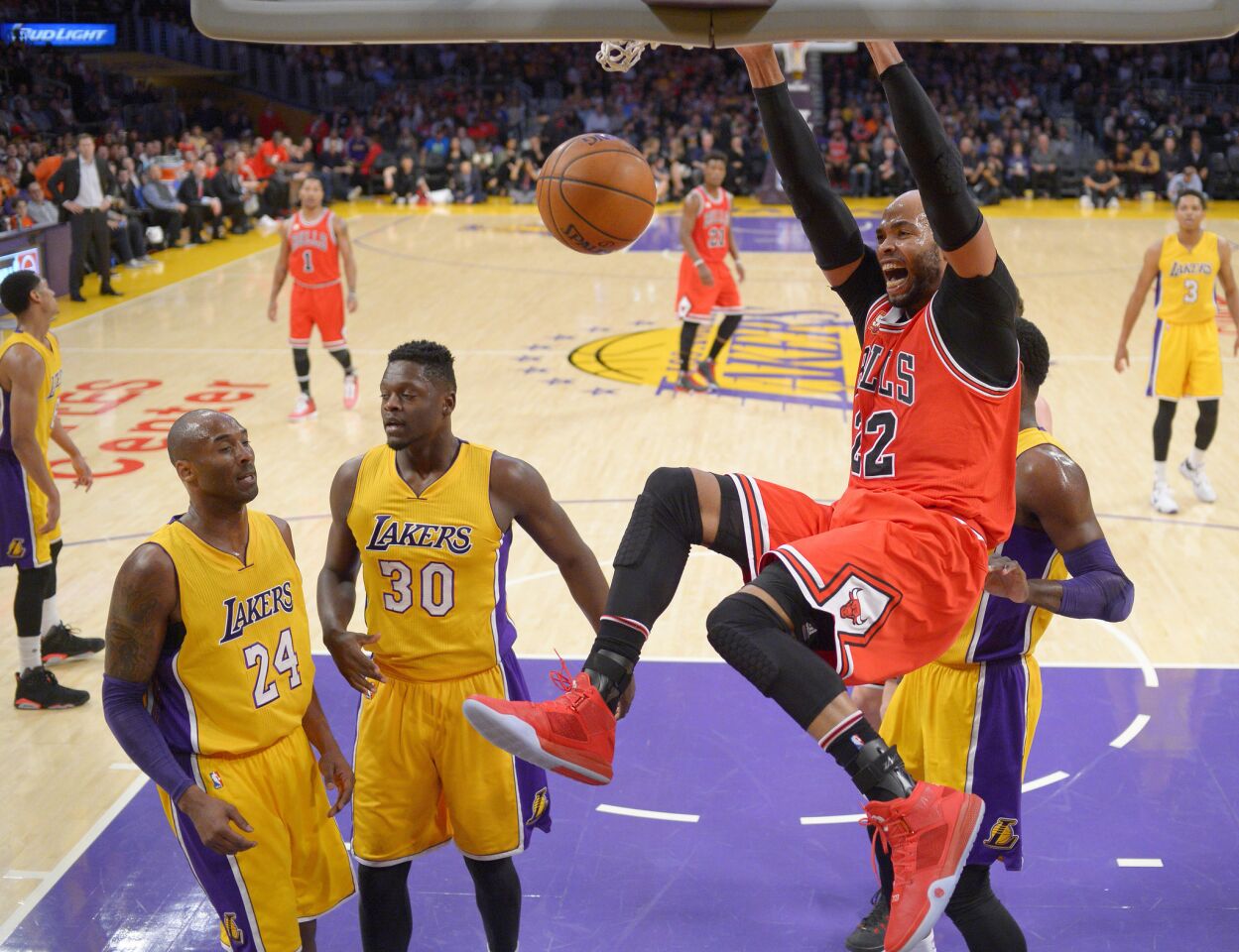 Bulls forward Taj Gibson, front right, dunks as the Lakers' Kobe Bryant (24) and forward Julius Randle (30) watch during the first half.