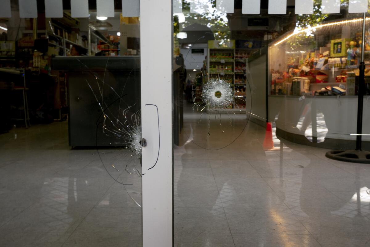 Los orificios de bala que impactaron las ventanas del supermercado Único, propiedad de la familia de su esposa