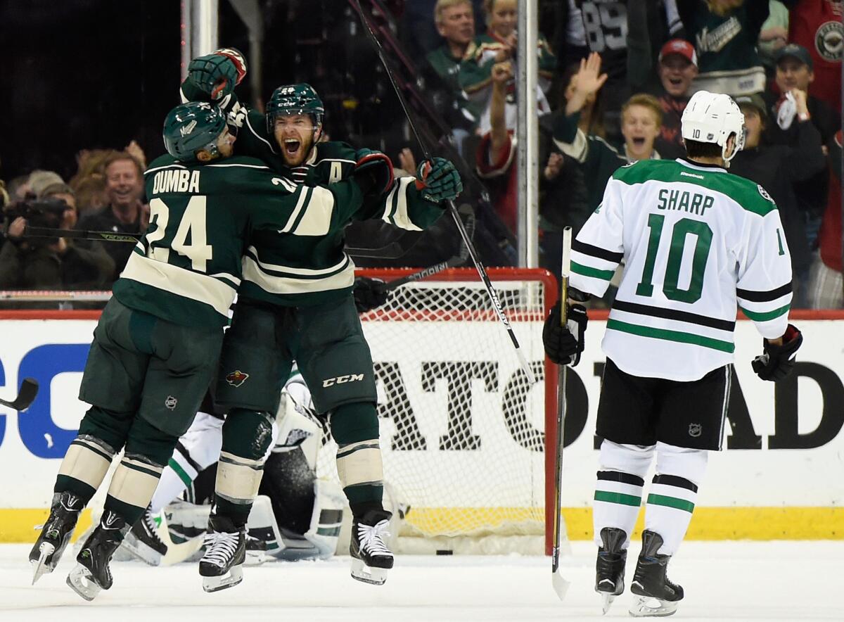 Wild defenseman Matt Dumba (24) celebrates with forward Jason Pominville (29) after Pominville scores in the second period against Patrick Sharp (10) and the Dallas Stars.