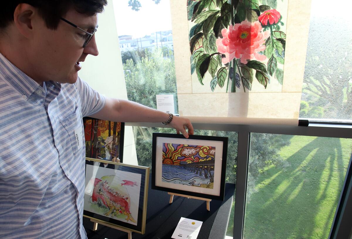 Zach Beckemeyer, 34, of Costa Mesa shows his art of the Newport Beach Pier during the Art of Epilepsy show.