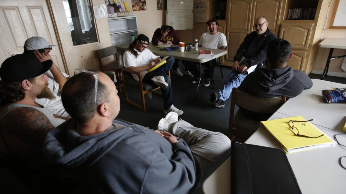 Program manager Dave Cross, right, leads a discussion about living in sobriety with inmates at an alternative custody program in Oroville.
