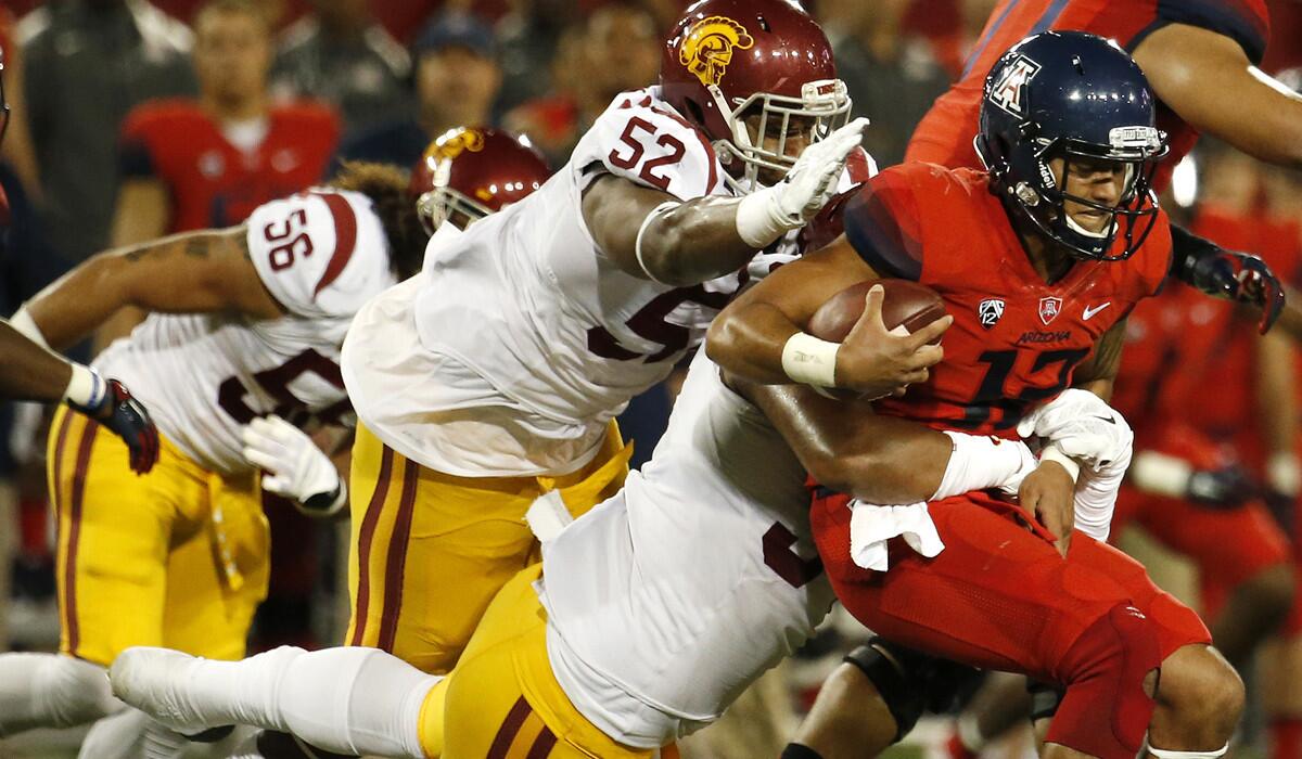 USC defensive tackle Delvon Simmons (52) and defensive end Leonard Williams (94) sack Arizona quarterback Anu Solomon. One of the two might end up playing nose tackle in the Holiday Bowl in place of injured Atwaun Woods.