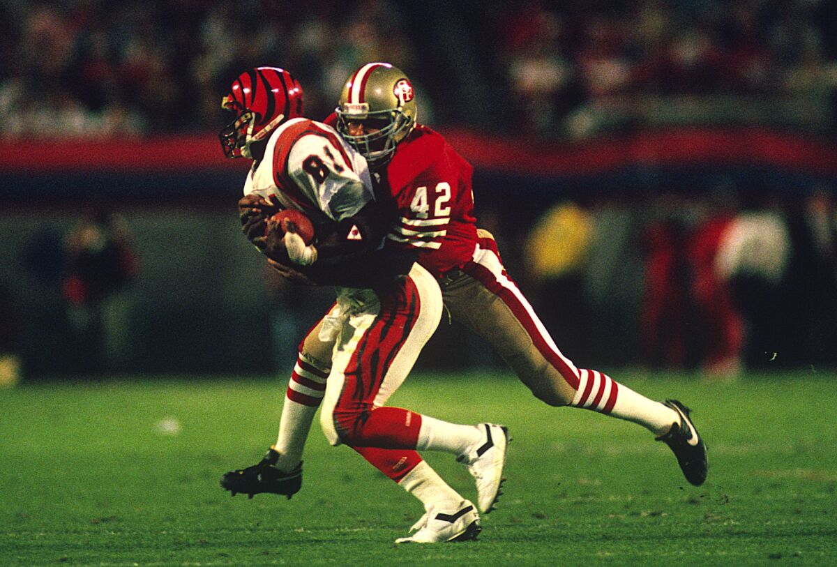 San Francisco  safety Ronnie Lott (42) stops Cincinnati  receiver Cris Collinsworth during Super Bowl XXIII in 1989 at Miami.