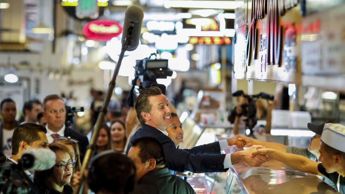 Gavin Newsom, Democratic candidate for governor, and former Los Angeles Mayor Antonio Villaraigosa campaign in Grand Central Market in downtown Los Angeles on Thursday, Nov. 1.
