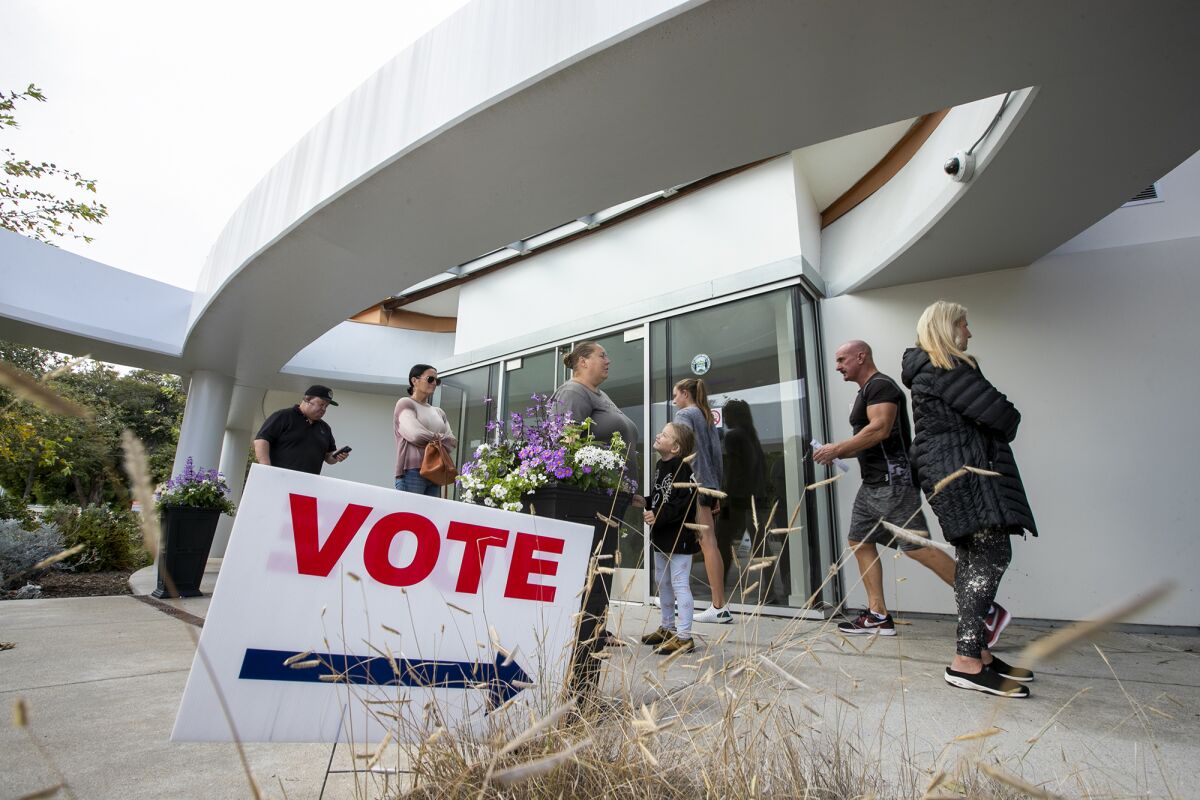People wait in line to vote at the Norma Hertzog Community Center in Costa Mesa on Election Day 2022.
