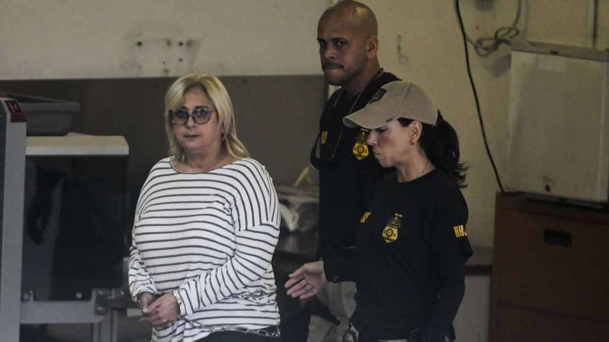 Federal agents escort Angela Avila-Marrero, who was arrested in San Juan, Puerto Rico, on Wednesday.