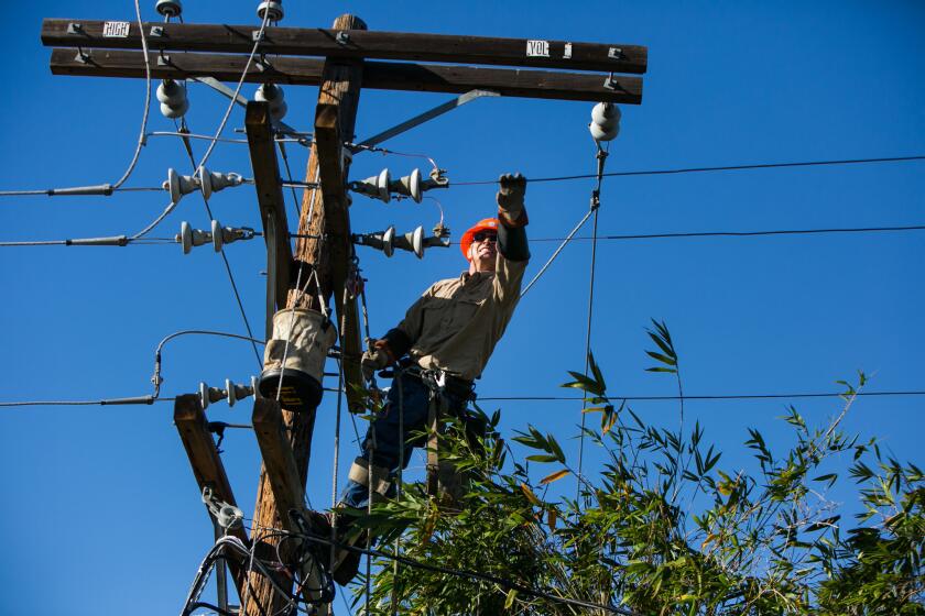 LOS ANGELES, CALIF. -- THURSDAY, DECEMBER 25, 2014: Power line patrolman Michael McGuire repairs the power lines that were damaged due to high winds in the Century City neighborhood, of Los Angeles, Calif., on Dec. 25, 2014. According to the Los Angeles Department of Water and Power, winds as fast as 40 miles per hour knocked out power to about 11,500 customers in areas such as Westwood, Northridge, Hollywood, downtown and Century City. About 6,700 customers were still without power at 9:45 a.m. Thursday. Power crews have been working on repairs and are expected to get most of the power restored by mid-to-late afternoon, DWP officials said. (Marcus Yam / Los Angeles Times)