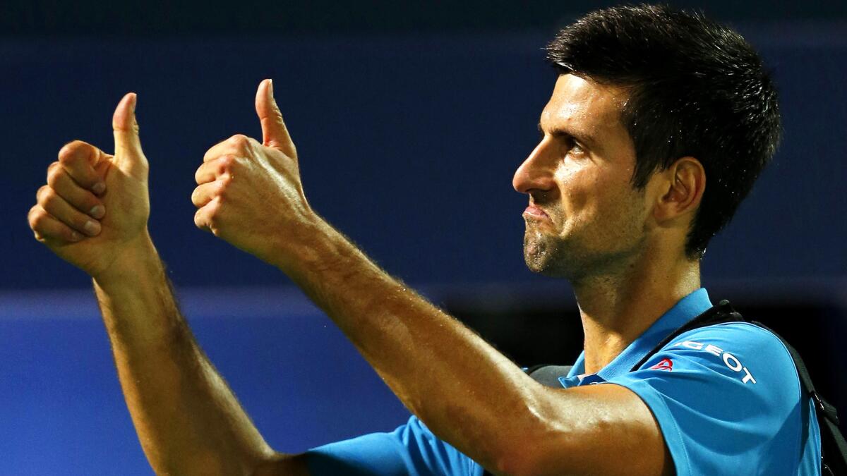 Novak Djokovic gives fans the thumbs-up sign while leaving the court after he withdrew from his quarterfinal match at the Dubai Tennis Championships on Thursday.