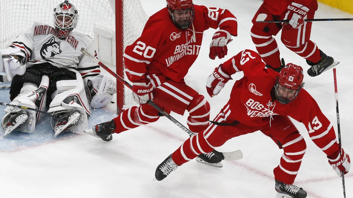 Boston University's Trevor Zegras (13) celebrates his goal as Northeastern  players look on during the first period of the Beanpot Tournament  championship NCAA college hockey game in Boston, Monday, Feb. 10, 2020. (