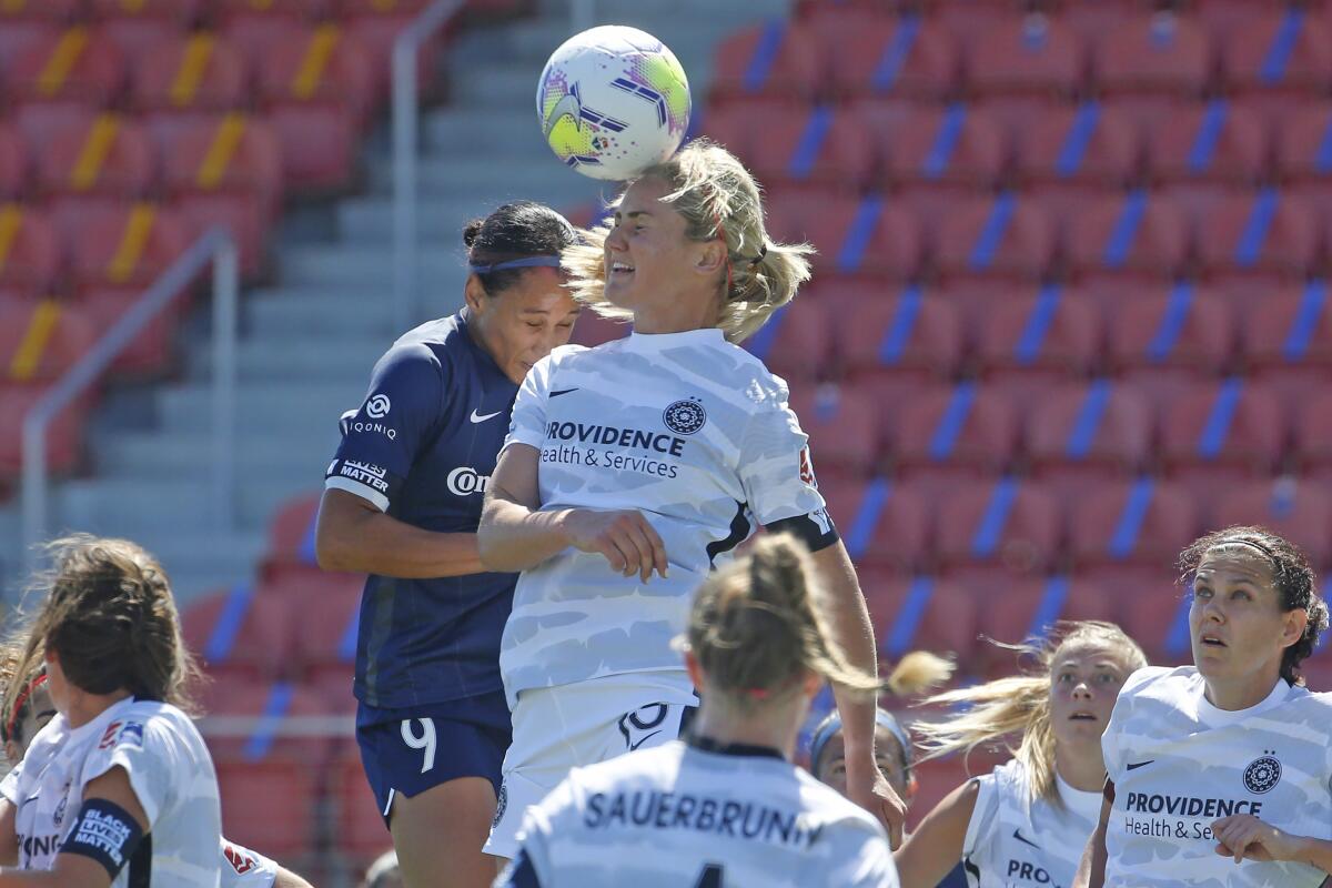 North Carolina's Lynn Williams and Portland's Lindsey Horan battle for the ball during the NWSL Challenge Cup on Saturday.