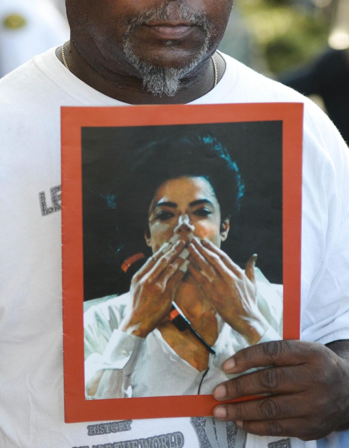 A fan holds a portrait of Michael Jackson outside court after Wednesday's verdict in the lawsuit filed by Jackson's family against AEG Live.