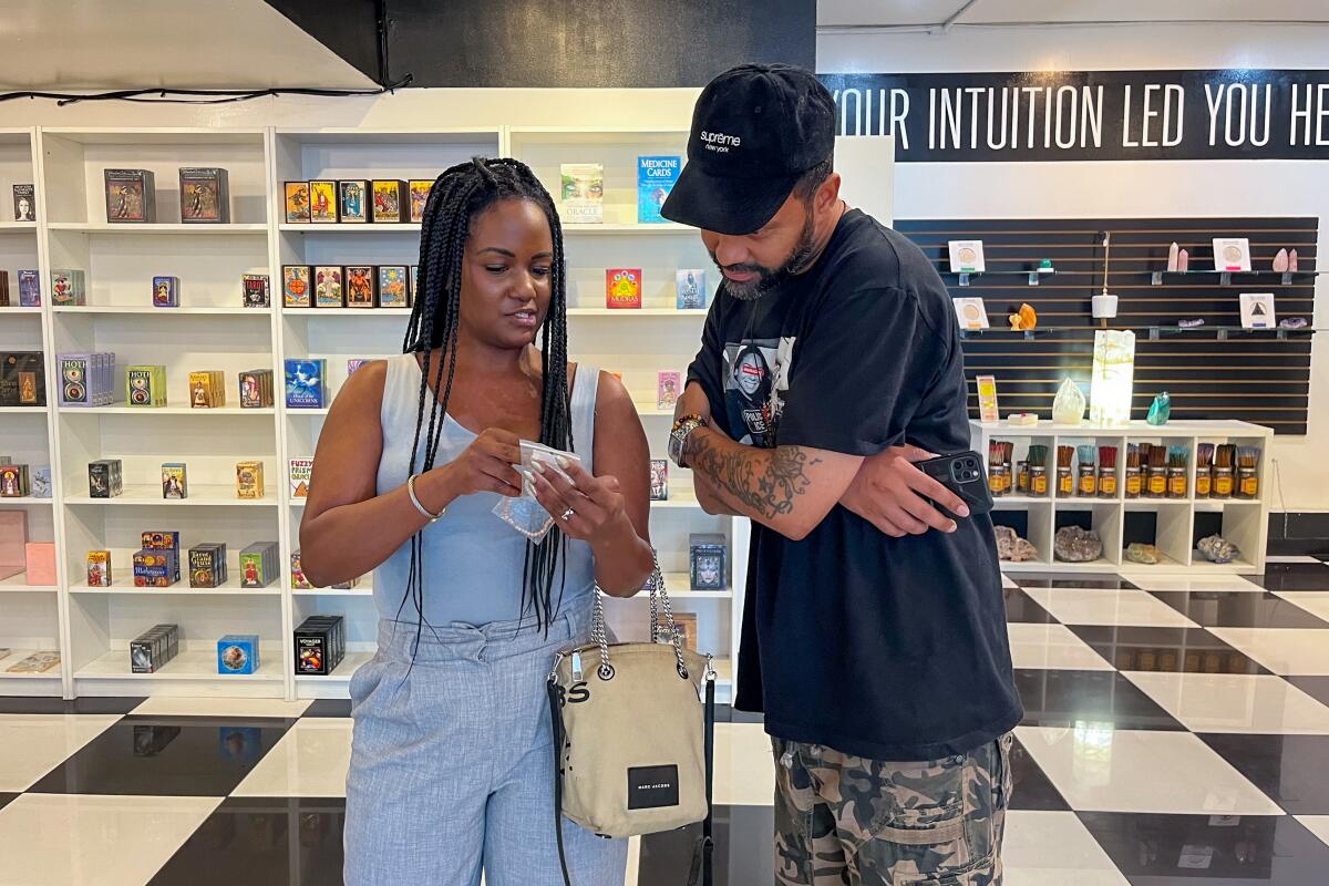  Customers examine an item at a spiritual goods store.