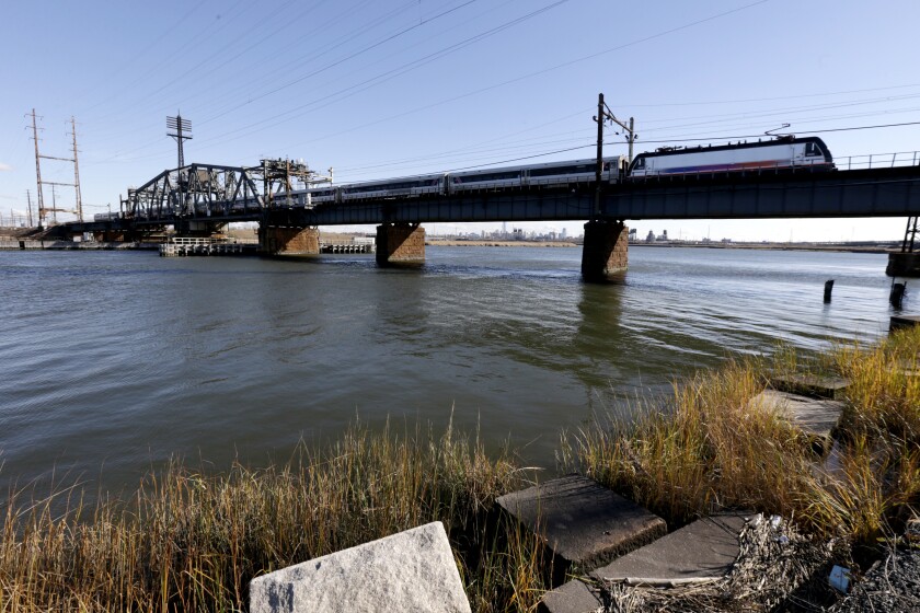 FILE - A New Jersey Transit train rides across a portal bridge over the Hackensack River, Friday, Nov. 14, 2014, in Kearny, N.J. Sediment in a 19-mile stretch of the Hackensack River in northern New Jersey has traces of arsenic, lead and other contaminants and is being named as a U.S. Environmental Protection Agency's Superfund site, federal and state regulators said Thursday. (AP Photo/Julio Cortez, File)