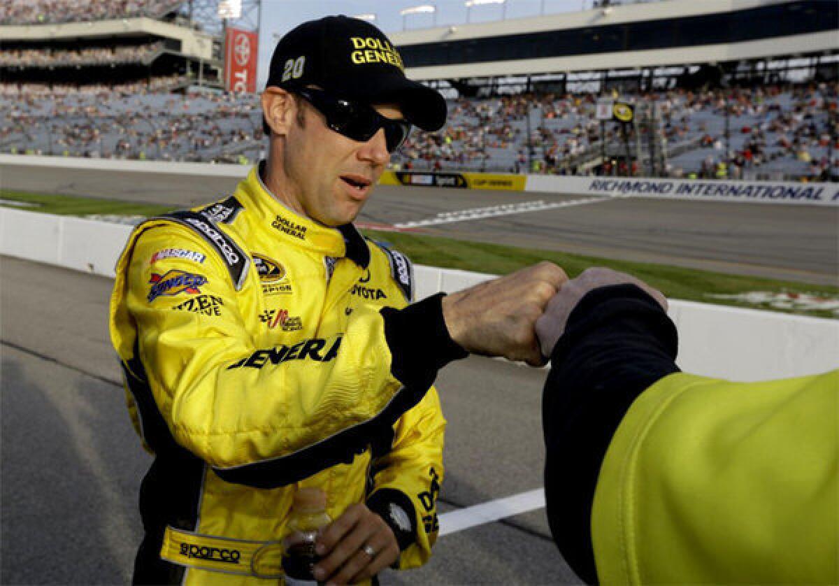 Matt Kenseth gives a fist bump to a crew member after winning the pole for Saturday's Sprint Cup race at Richmond International Raceway.