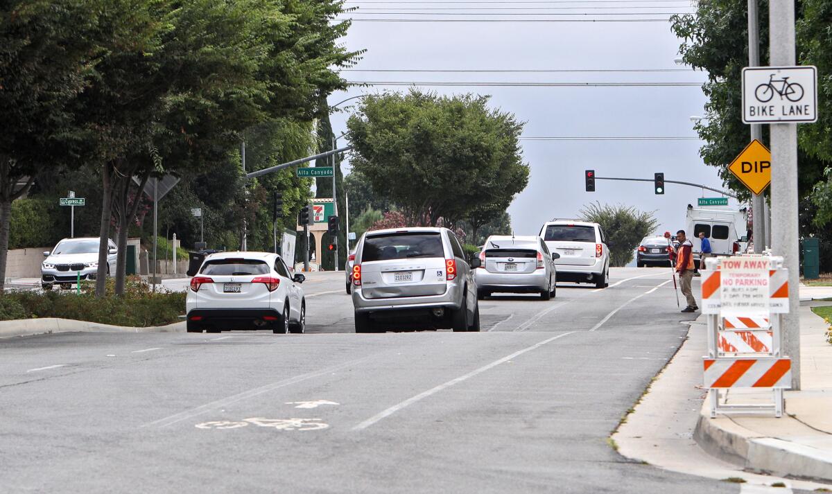 Vehicles pass a large dip on the road on the 1700 block of Foothill Boulevard in La Cañada Flintridge, on Tuesday, Sept. 10.