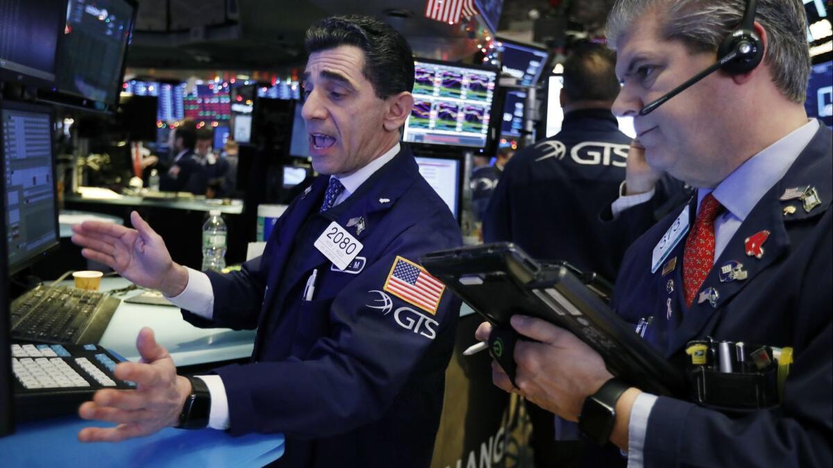 Specialist Peter Mazza, left, and trader John Panin work on the floor of the New York Stock Exchange on Dec. 6.