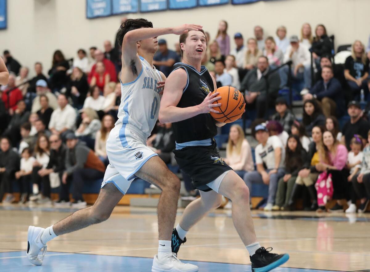 Marina's Dylan Gomez holds off CdM defender Luke Mirhashemi for a layup.