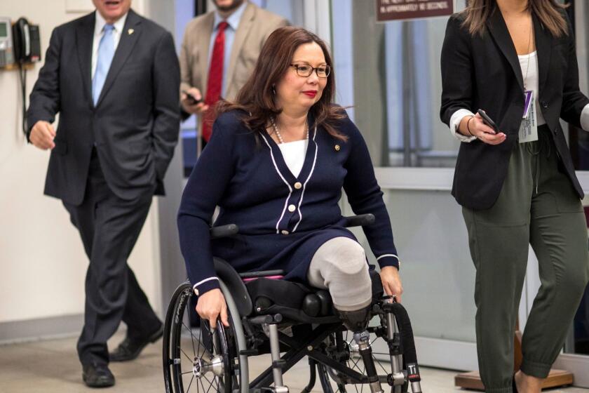 Sen. Tammy Duckworth, D-Ill., and other senators arrive to vote on the confirmation of Samuel Brownback, governor of Kansas and a former U.S. senator, to become the ambassador-at-large for international religious freedom, at the Capitol in Washington, Wednesday, Jan. 24, 2018. (AP Photo/J. Scott Applewhite)