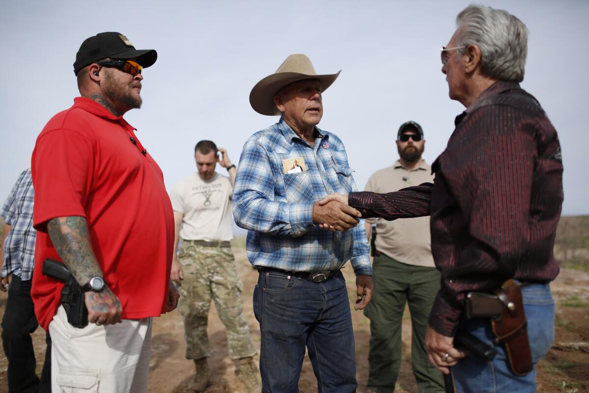 Rancher Cliven Bundy, center, meets with supporters in Nevada last week.