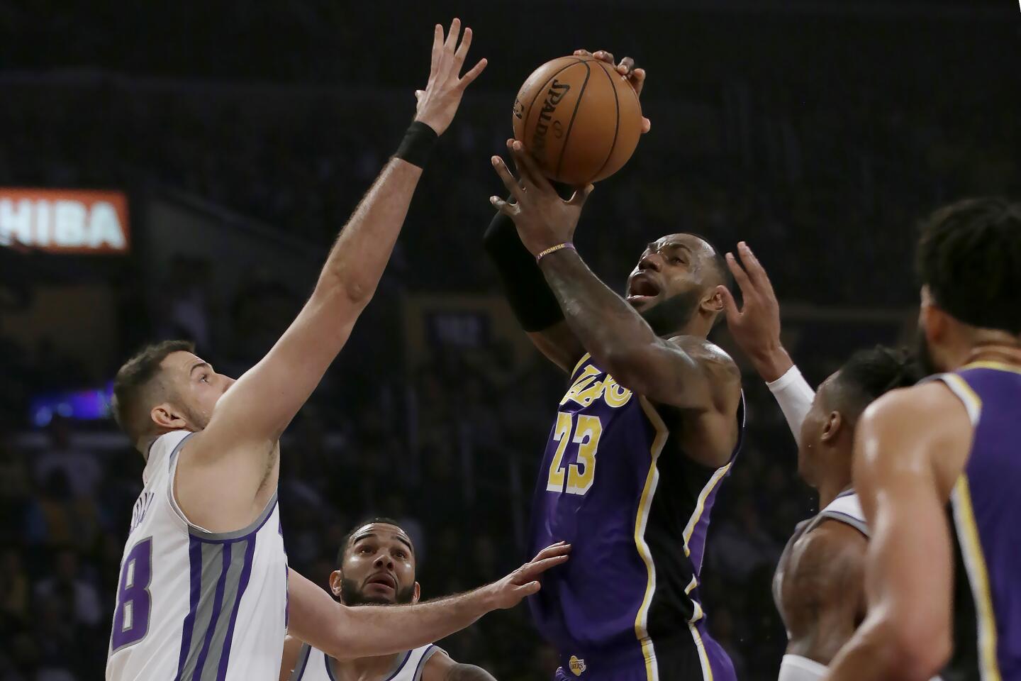 Lakers forward LeBron James, center, drives to the basket against the Sacramento Kings.
