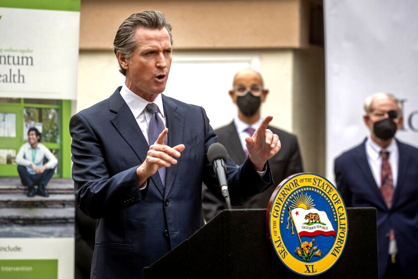 Gov. Gavin Newsom, speaking at a mental health treatment center in San Jose, Calif., announces "Care Court," a program that would target people suffering from psychosis who have lost their ability to care for themselves, Thursday, March 3, 2022. California's governor is proposing a plan to offer more services to homeless people with severe mental health and addiction disorders even if that means forcing some into care. Newsom was joined by Dr. Mark Ghaly, center, Secretary of the California Health & Human Services and Santa Clara County Judge Stephen Manley. (Karl Mondon/Bay Area News Group via AP)