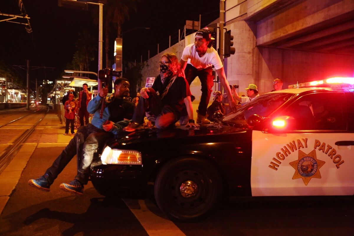 Protesters climb on a CHP vehicle on Hope Street in Los Angeles.