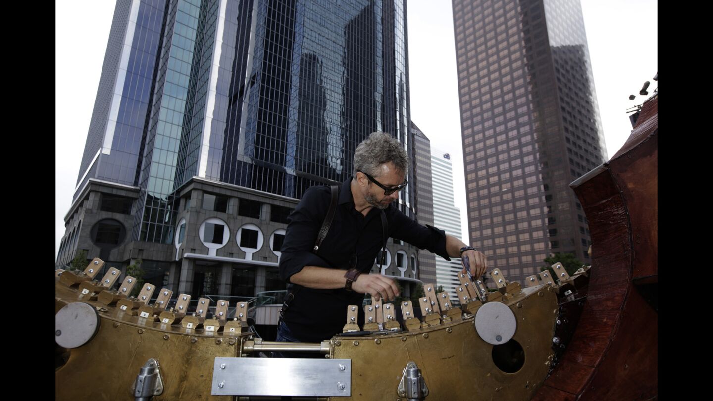 William Close works on his Earth Harp, the longest stringed instrument in the world, ahead of performances at California Plaza in downtown L.A. Close was stringing the harp to a skyscraper in the plaza.