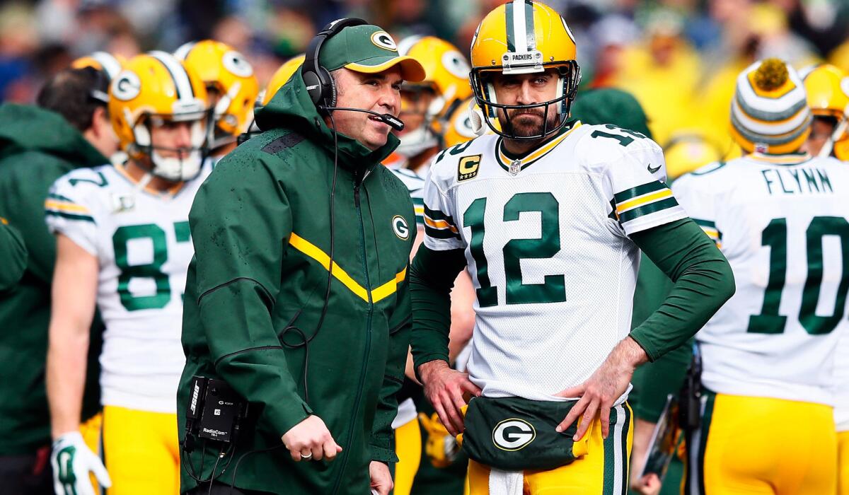Packers Coach Mike McCarthy talks to quarterback Aaron Rodgers (12) during the NFC championship game against the Seahawks.