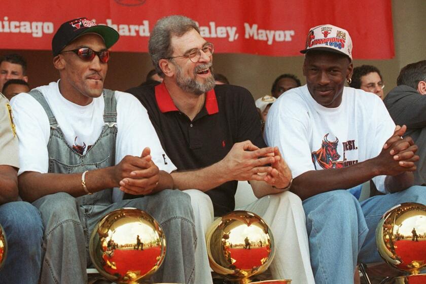 Chicago Bulls, from left: Dennis Rodman, Scottie Pippen, coach Phil Jackson, and Michael Jordan, sit with four NBA trophies at their feet during the championship celebration Tuesday, June 18, 1996, in Chicago's Grant Park. The Bulls have won four NBA titles in six years; and, the hometown heroes promised the thousands of fans gathered Tuesday, more championships to come. (AP Photo/ Beth A. Keiser)