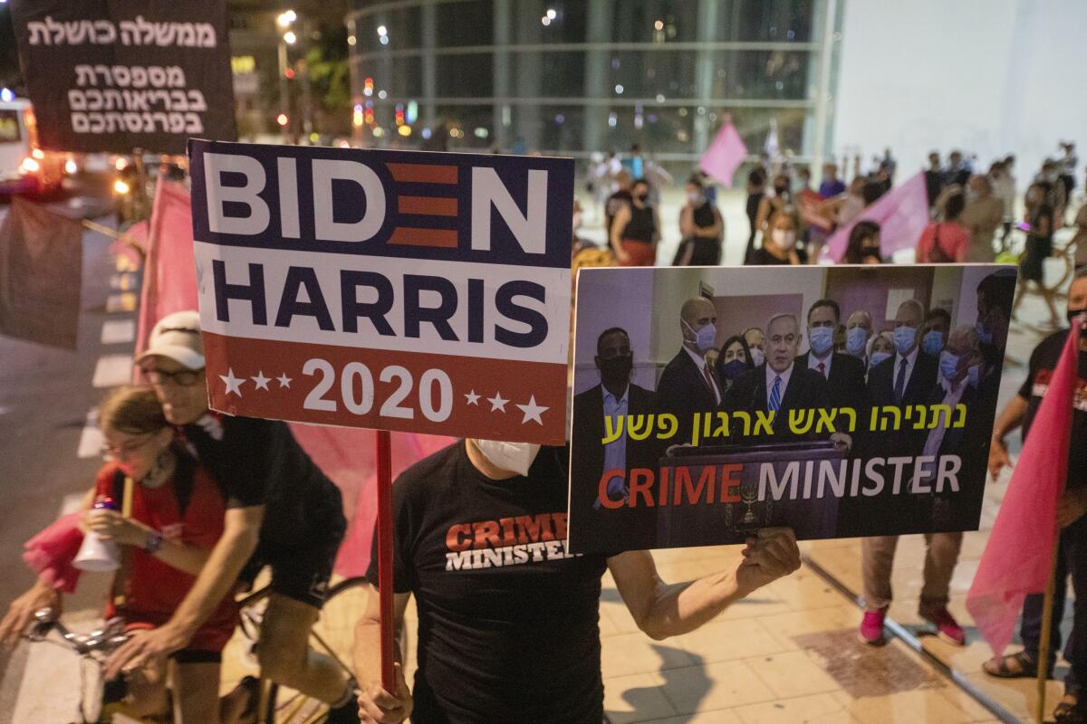 A protester holds a sign declaring Benjamin Netanyahu "crime minister" in Tel Aviv on Oct. 15.