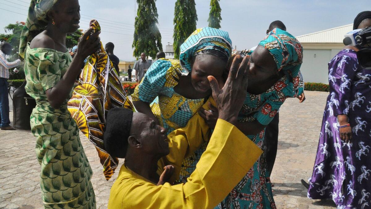 Family members celebrate as they embrace a relative, one of the released kidnapped schoolgirls, in Abuja, Nigeria, Saturday, May 20, 2017.